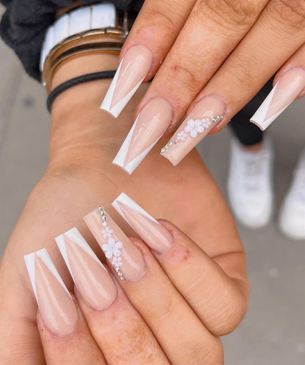 Long nude coffin nails with white tips, glitter and a single flower accent