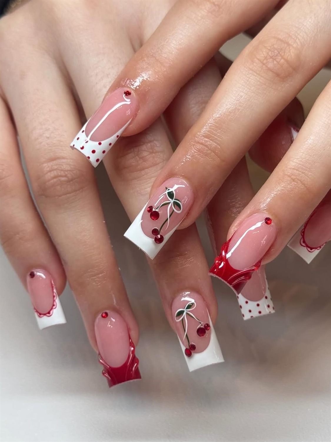 White French tips with hand-painted red cherries, red tips and polka dots