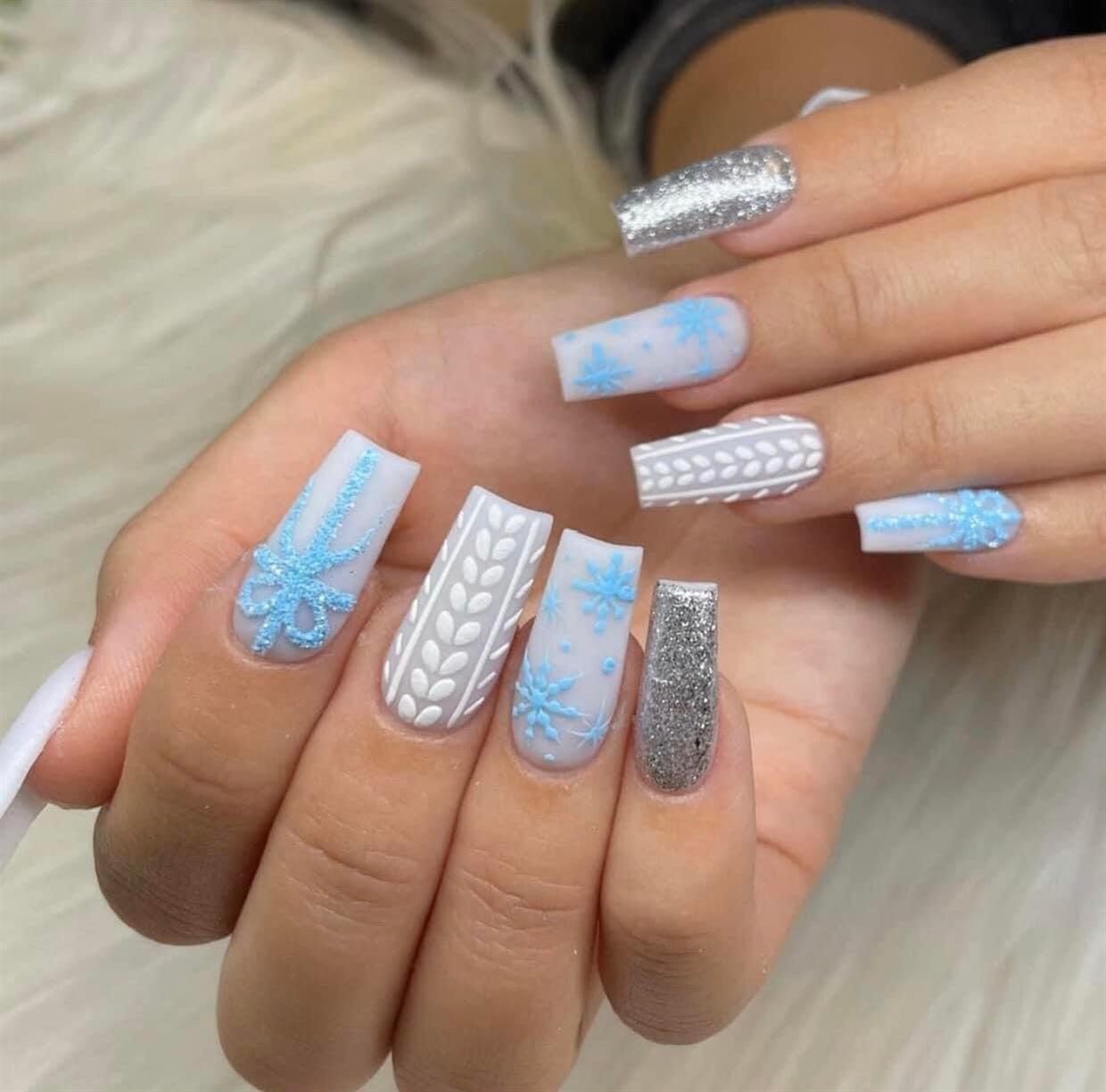 Long coffin nails in pale blue with knitted texture, snowflakes and silver glitter